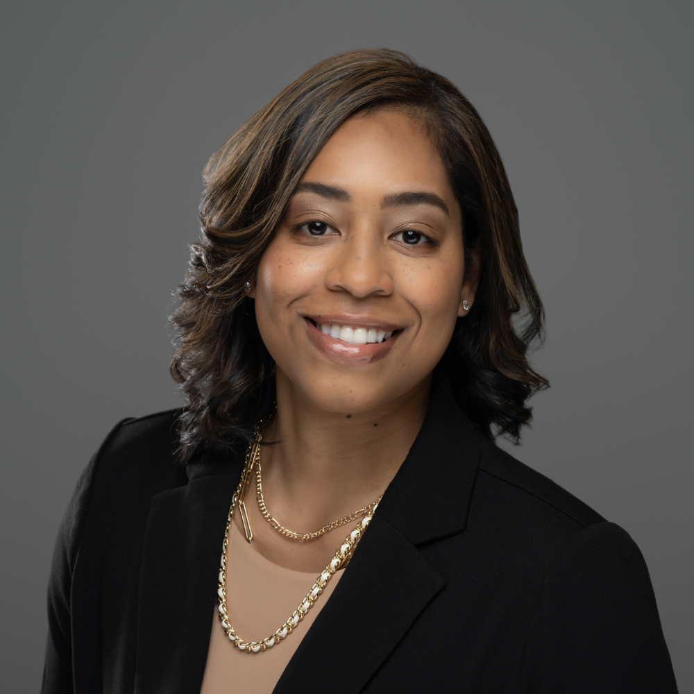 Professional headshot of Olga Perozo smiling confidently in a black blazer.